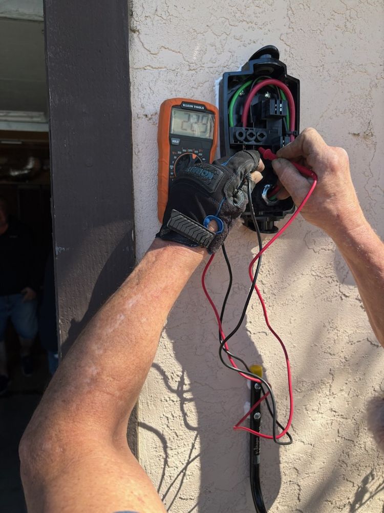 Electrician testing an EV charger circuit with a multimeter